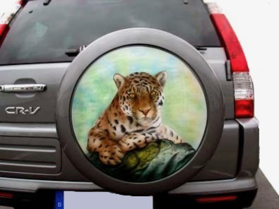 Rückansicht eines silbernen Autos, welches auf seinem außenliegenden Ersatzreifen das Airbrush-Bild eines Tigers hat