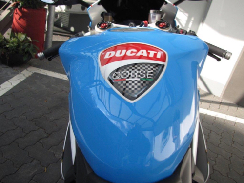 Draufsicht auf ein blau-weißes Motorrad mit einem Ducati Logo auf dem Stauraum