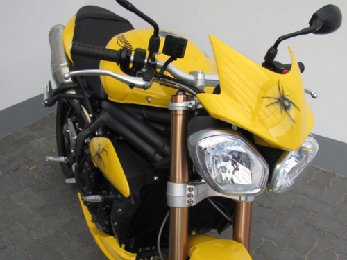 Frontansicht eines gelb-schwarzen Motorrads mit einer mit Airbrush aufgetragenen Spinne vorne auf dem Lenker